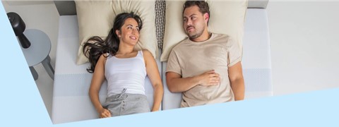 Een man en een vrouw die in bed liggen