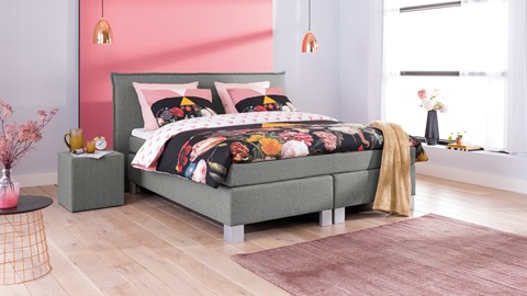 een bed met een roze muur