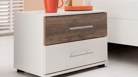 Een wit dressoir met een rode mok erop