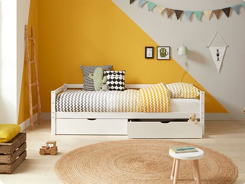 een kinderkamer met een bed en een kleed