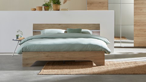 een bed met een houten hoofdeinde