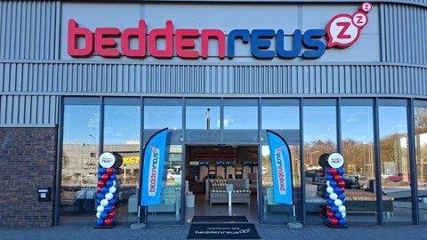 een winkelpui met een bord en ballonnen