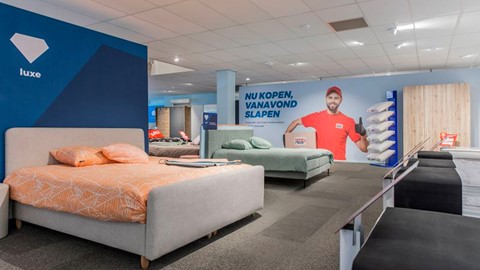 een kamer met bedden en een poster aan de muur