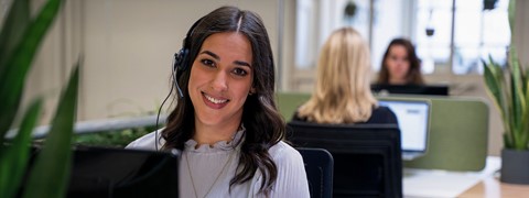 Een vrouw die bij camera glimlacht