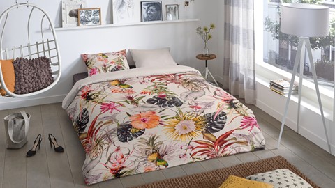 een bed met een bloemendekbed en kussens