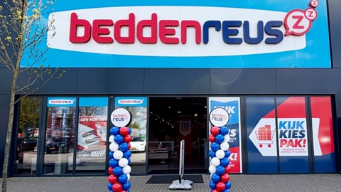 een winkelpui met een bord en ballonnen