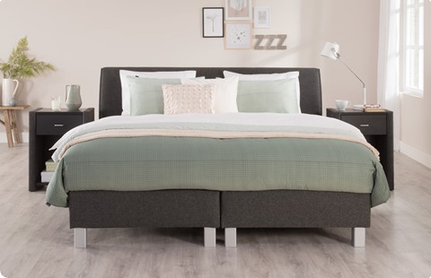 een bed met kussens en een lamp
