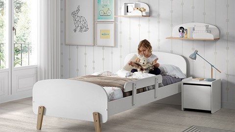 Een meisje dat een boek op een bed leest