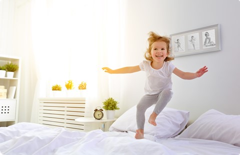 Een meisje dat op een bed springt