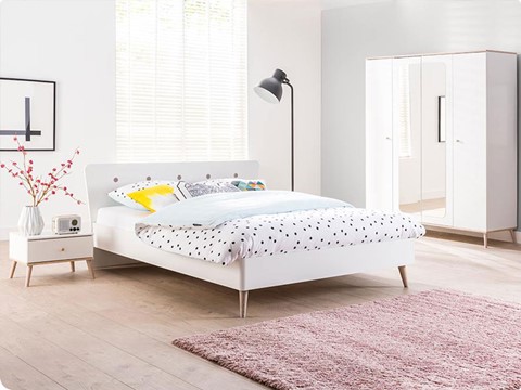 een wit bed met zwarte stippen erop