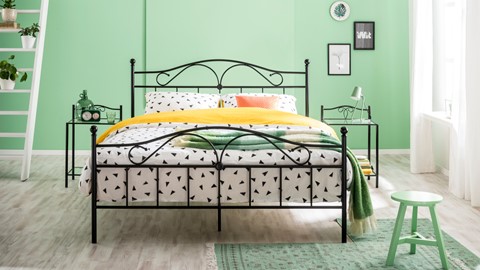 een bed met een gele deken en zwarte driehoeken erop