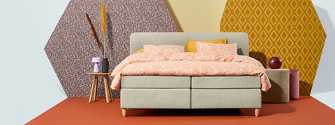 een bed met oranje en wit beddengoed